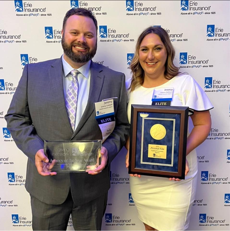 Photo of owners Jessica and Jeremy holding insurance awards